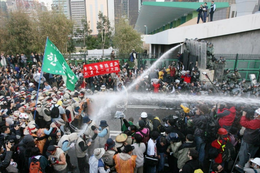 South Korean protesters throw ladders belonging to the media during a clash with riot police in Hung Hing Road, Wan Chai. Photo: Felix Wong