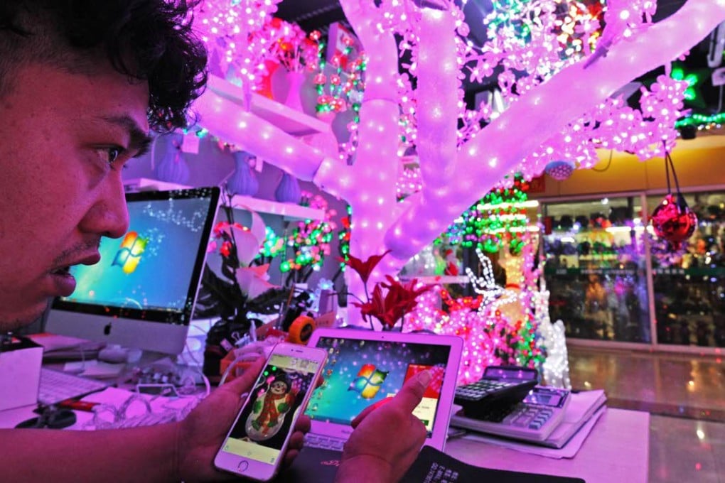 A trader discusses business via Mobile WeChat at the International Trading Mall in Yiwu, Zhejiang province. Photo: Xinhua