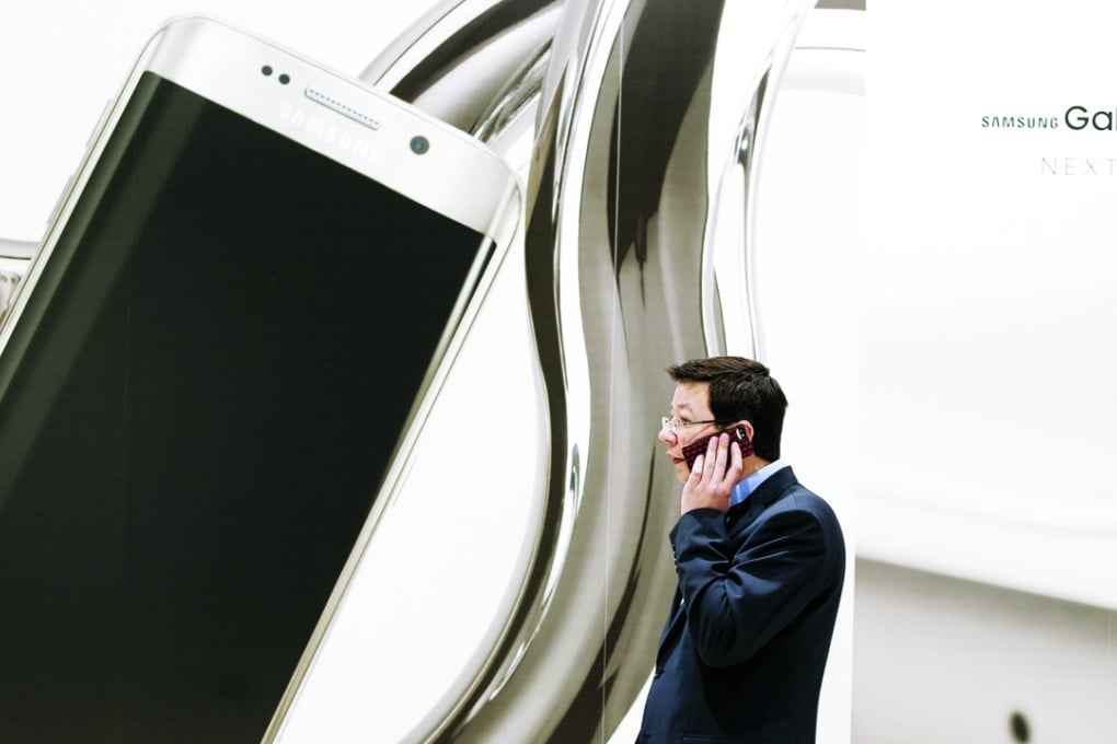 A man talks on a phone next to the Samsung stand at last year’s Mobile World Congress in Barcelona, considered the most important event in the mobile industry worldwide. Photo: Corbis