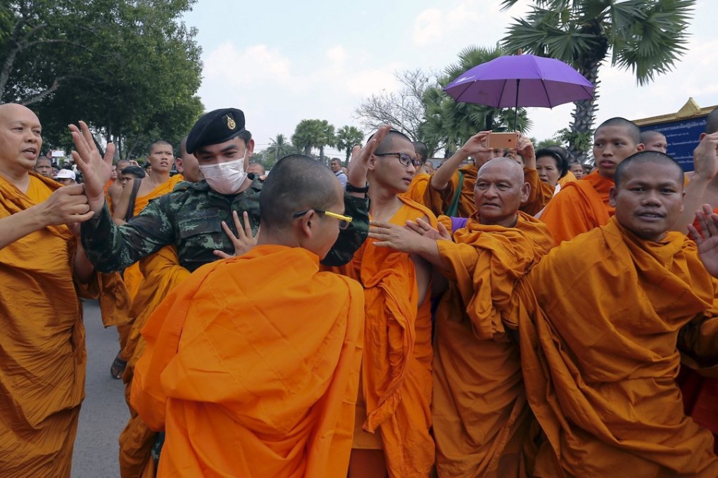Buddhist monks scuffle with a soldier during a protest against state interference in religious affairs near a temple in Nakhon Pathom province on the outskirts of Bangkok, Thailand. Photo: Reuters