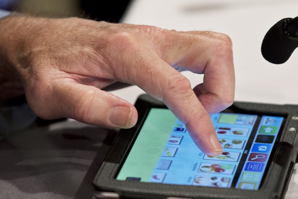 Robert Voogt uses the communication device MiniTalk to answer questions during a news conference in Washington on Sunday. Photo: AP