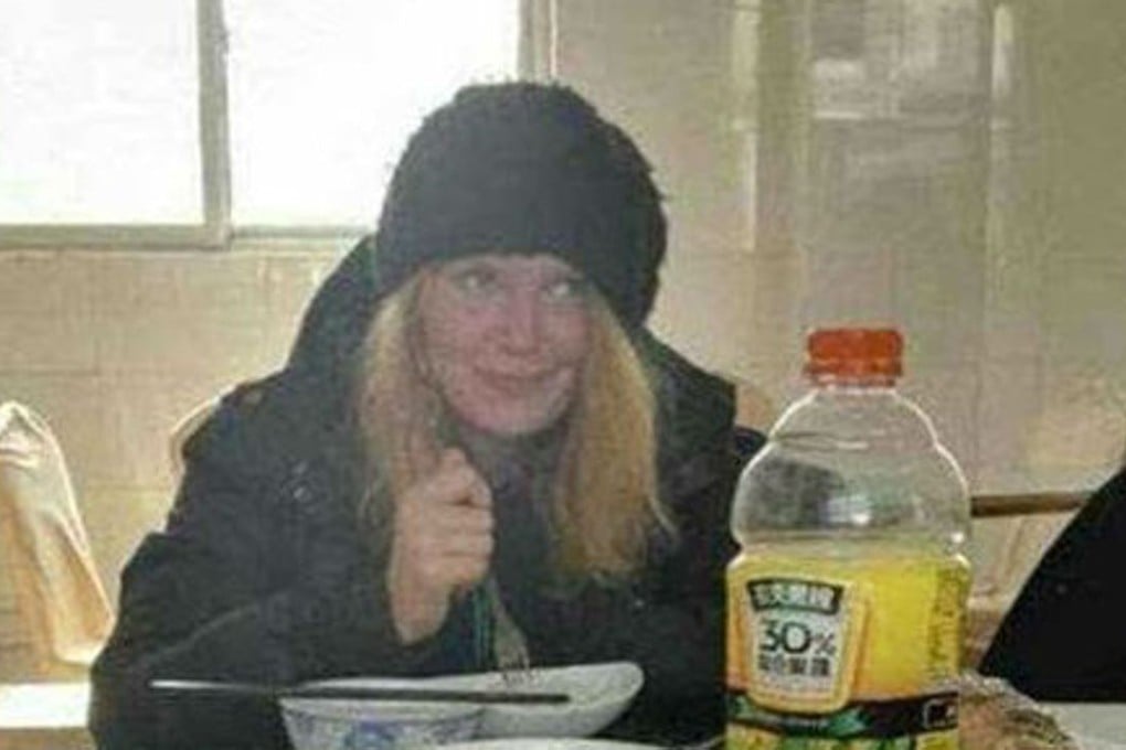 The Russian hitchhiker, found starving and penniless while walking along a Chinese expressway on Sunday, enjoys a hot meal thanks to mainland police. Photo: SCMP Pictures