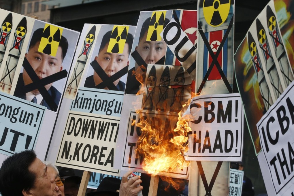 An protester in South Korea burns pictures of North Korea’s leader Kim Jong-un and pictures of Pyongyang’s missiles during a protest rally in Seoul, South Korea, last Thursday following this month’s rocket launch. Photo: AP
