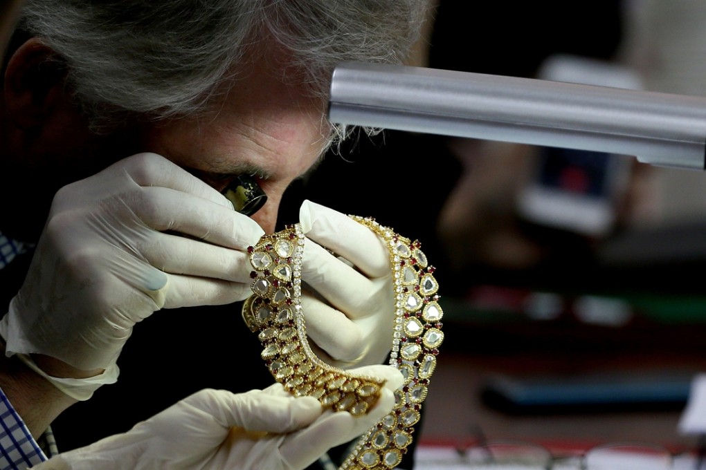 Christie's auction house appraiser David Warren examines a set of jewellery from the Marcos collection in Manila. File photo: AP