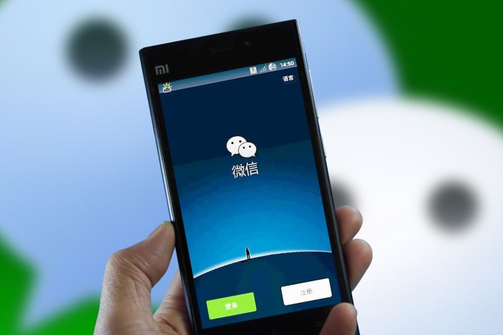 A man uses Tencent’s messaging app Weixin, or WeChat, on his smartphone in eastern China's Shandong province. WeChat Wallet is used widely in mainland China, whereas Hong Kong is moving slower to adopt similar services. Photo: Imaginechina