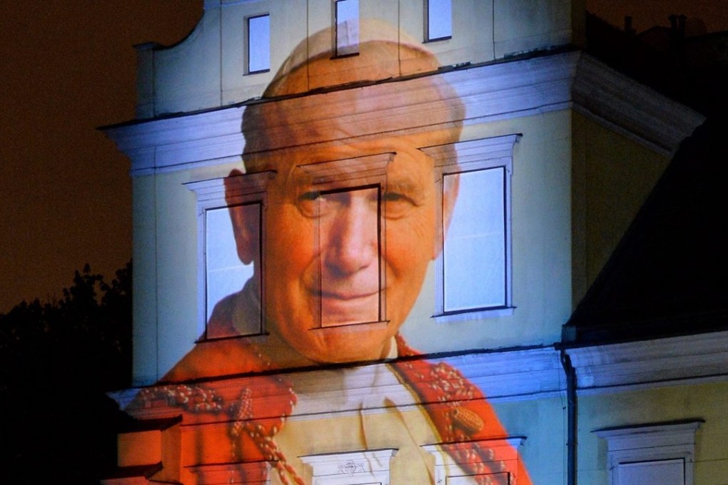 A light installation dedicated to Pope John Paul II in front of the Archdiocese of Krakow, in Poland. Photo: EPA