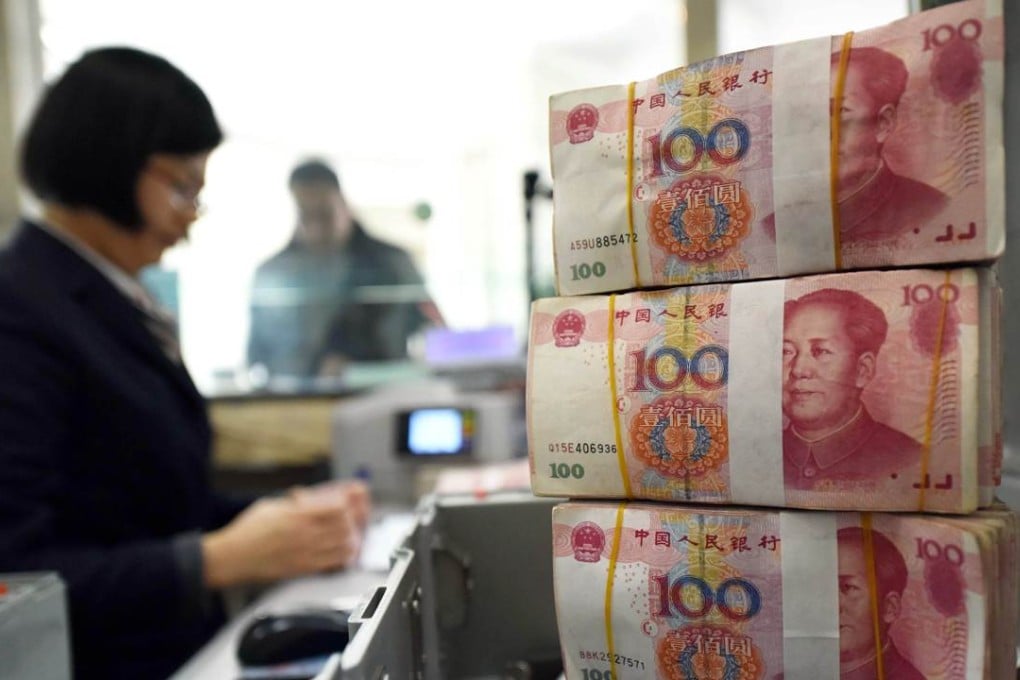 An employee counts 100-yuan banknotes at a bank in China. Photo: AFP