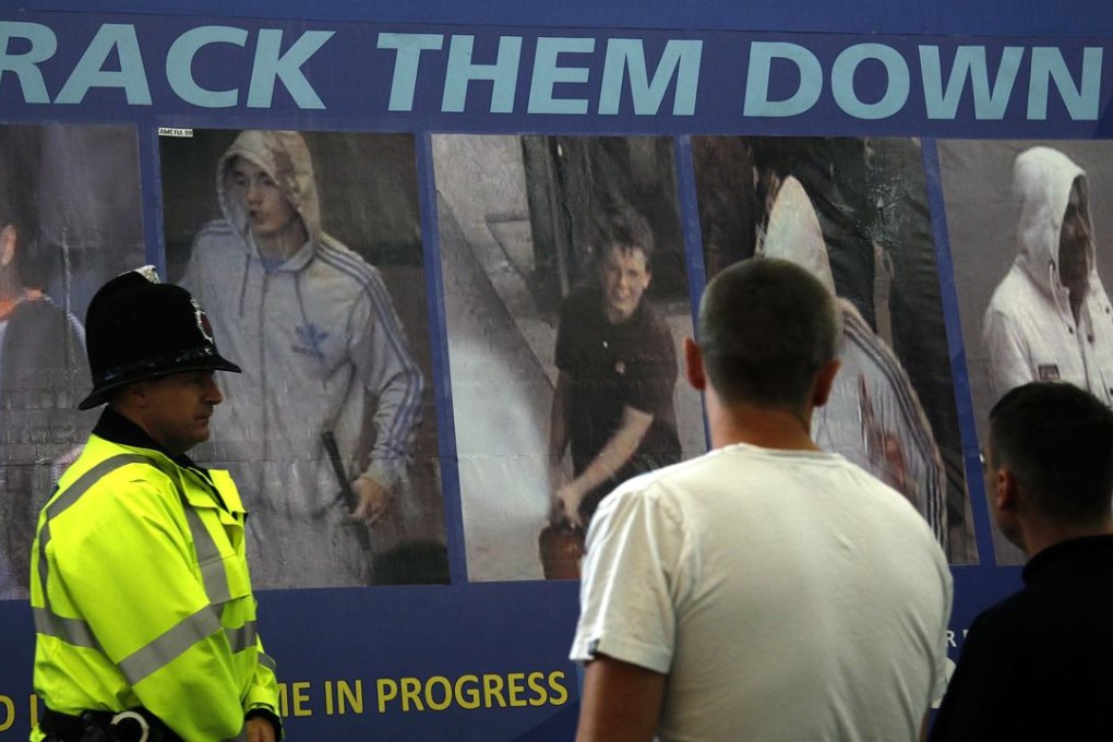 Men look at a Greater Manchester Police advertising board displaying images of people suspected of committing crimes during riots in Manchester, northern England, in August 2011. Photo: Reuters