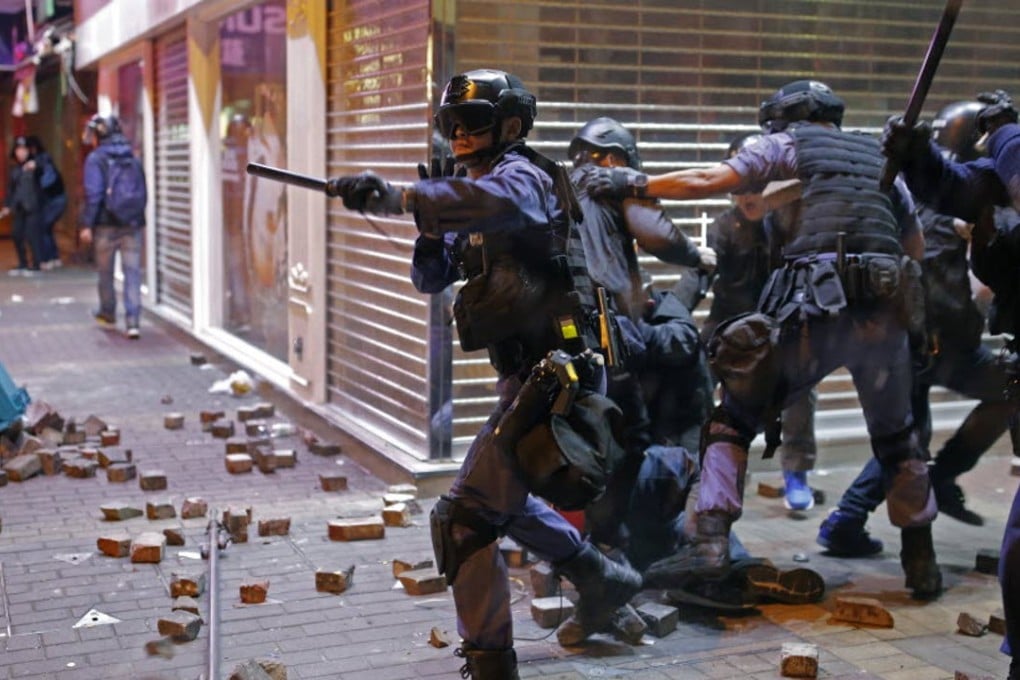 Riot police officers react as rioters set fires and throw bricks at them in Mong Kok on February 9. Photo: AP