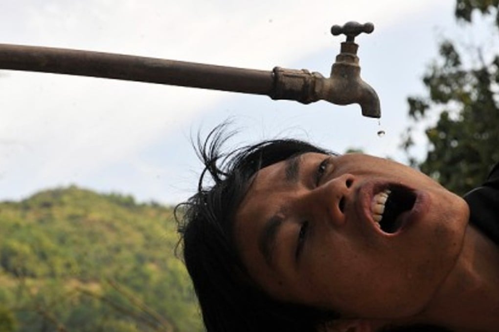 A villager squeezes out a few drops of water in Zhongbang, Guangxi Zhuang Autonomous Region - but is he inadvertently swallowing superbug? Photo: Xinhua
