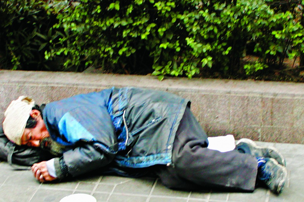 An elderly beggar sleeps on the street in Shenzhen. Some 71 million people live in poverty in China. Photo: SCMP Pictures
