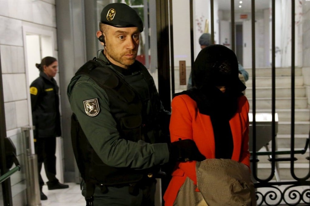 One of the directors of the Industrial and Commercial Bank of China’s Madrid office is lead away from the bank’s headquarters after being arrested during a raid on Wednesday. Photo: Reuters