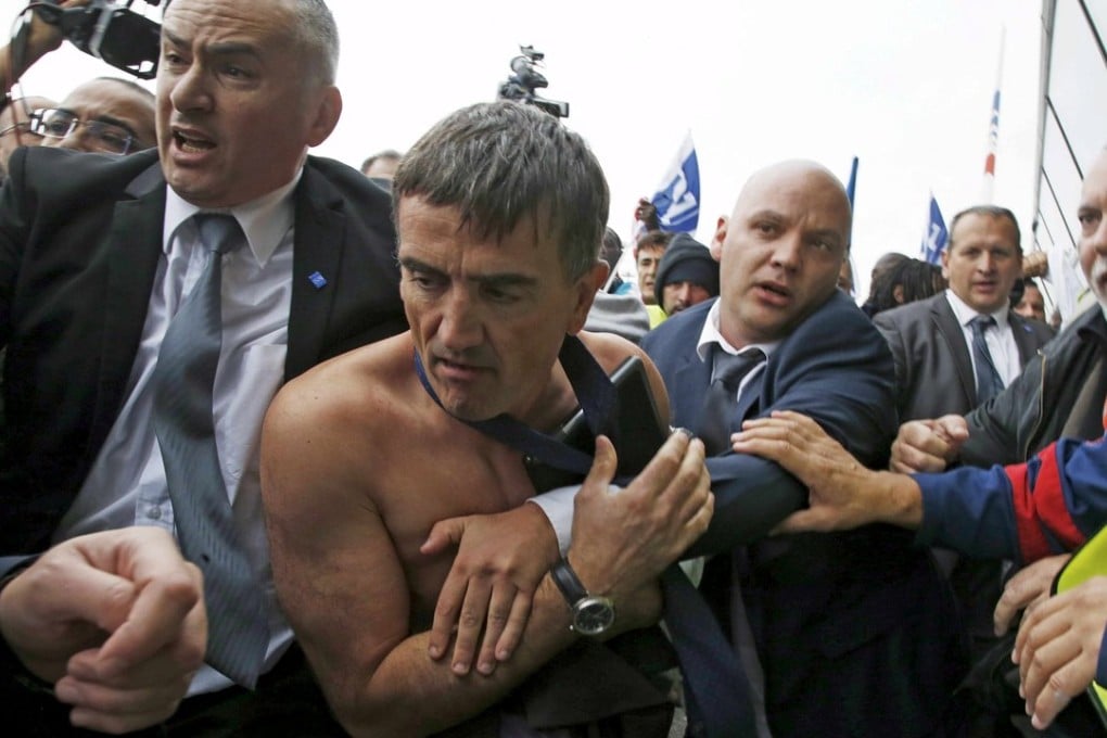 A shirtless Xavier Broseta, Air France’s executive vice-president for human resources and labour relations, is evacuated by security personnel after angry employees stormed a meeting with staff representatives in October. Photo: Reuters