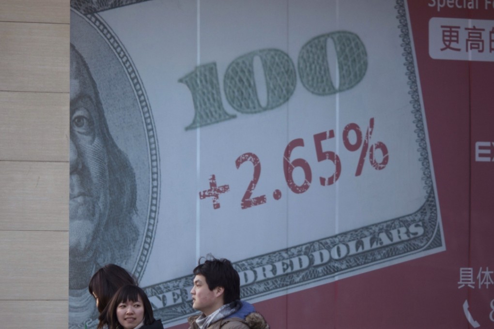 Chinese pedestrians walk past a giant US dollar note on a display board of a bank in Beijing. Photo: AP