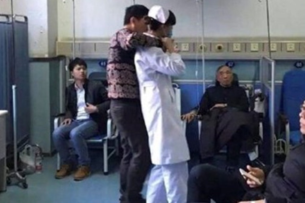A Chinese hospital patient presses a knife to the throat of a nurse while holding her hostage in Nanjing on Thursday. Photo: Sina.com.cn