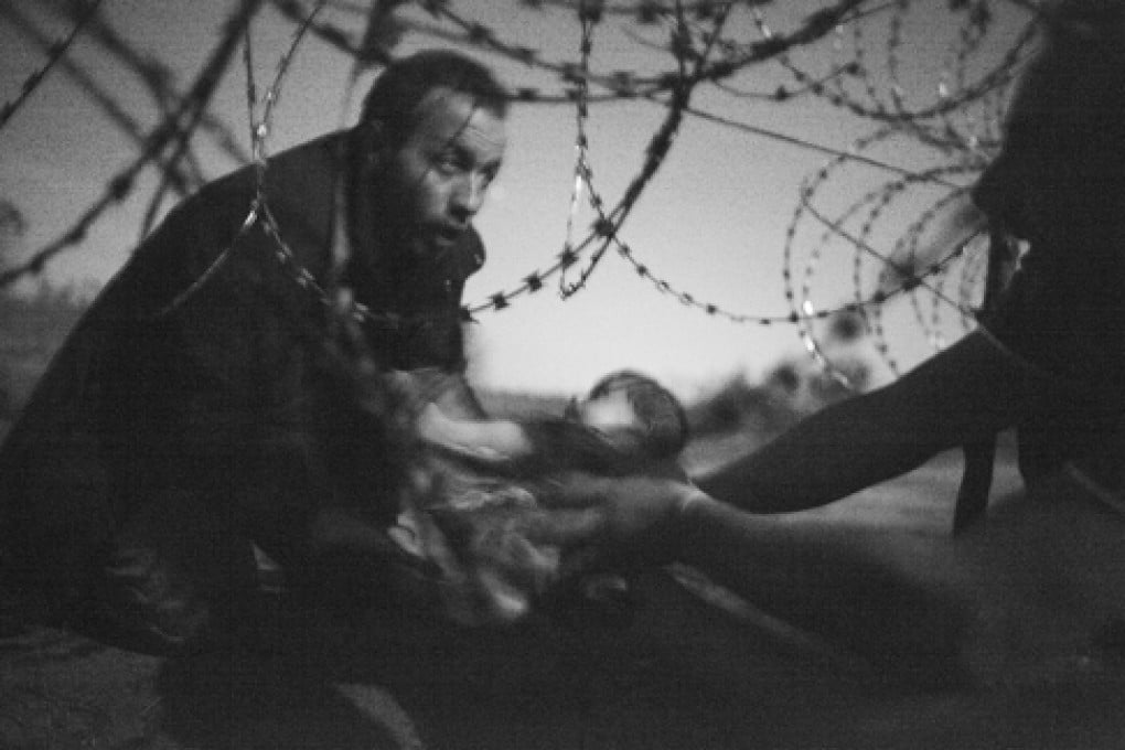 A picture by Australian photographer Warren Richardson that won the World Press Photo of the Year award and 1st prize singles in the Spot News category of the 59th annual World Press Photo Contest. The picture shows man passing a baby through the fence at the Serbia/Hungary border in Roeszke, Hungary on August 28, 2015.