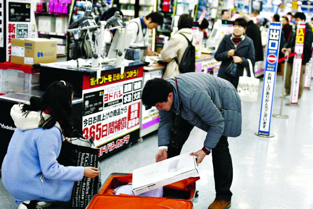Chinese tourists pack their shopping into a suitcase at a department store in Tokyo, Japan. Photo: Reuters