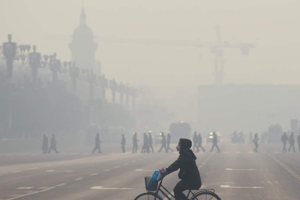 A woman rides her bicycle near Tiananmen Square on the third day of a "red alert" for pollution in Beijing on December 21, 2015. Photo: AFP