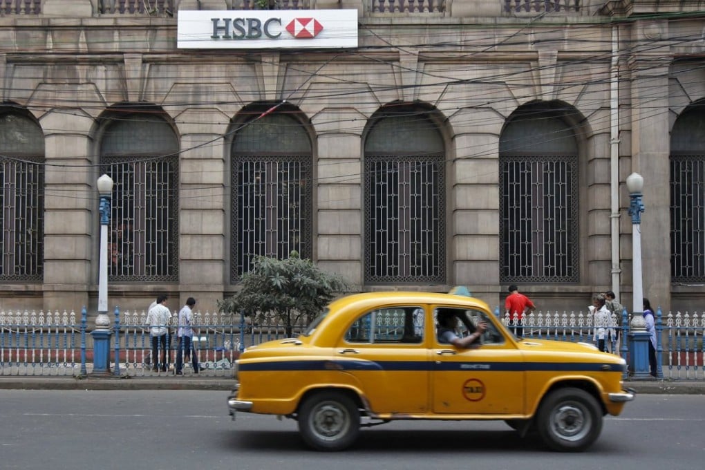 A yellow ambassador taxi drives past the HSBC bank building in Kolkata in this file photo. Photo: Reuters