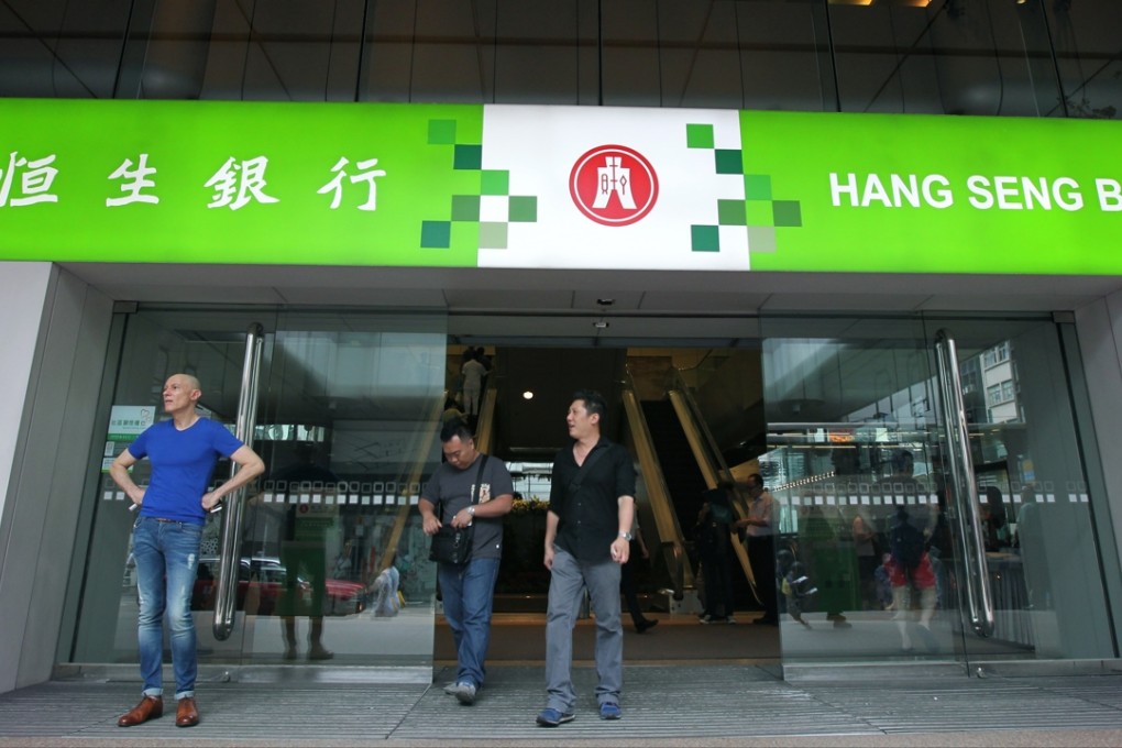 People walk past a branch of Hang Seng Bank in Central. Photo: May Tse