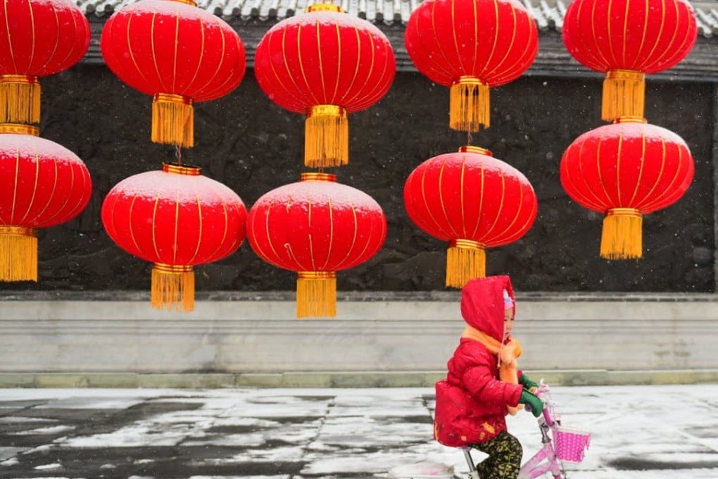 A girl rides her bike past giant lanterns in Changchun, northeast China’s Jilin Province. Photo: Xinhua/Lin Hong