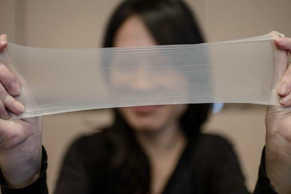 A woman stretches a piece of latex, with a thickness of just 0.036mm, made by Chinese company Guangzhou Daming Lianhe, which makes the world’s thinnest condoms. Photo: AFP