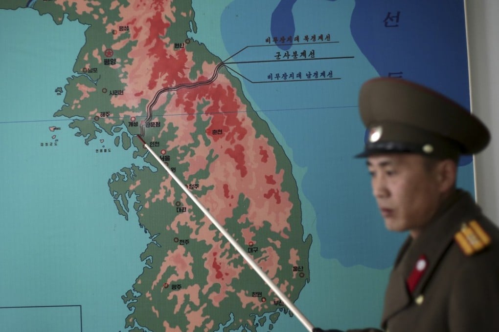 Korean People's Army Lt. Col. Nam Dong points to the line separating North and South. Photo: AP