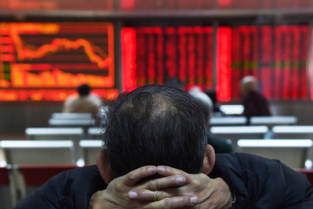 An investor watches price movements on screens at a securities company in Beijing. Photo: AFP