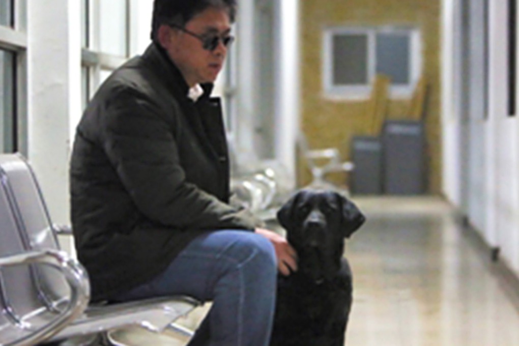 Masseur Tian Fengbo with his guide dog “Qiaoqiao”. Photo: SCMP Pictures