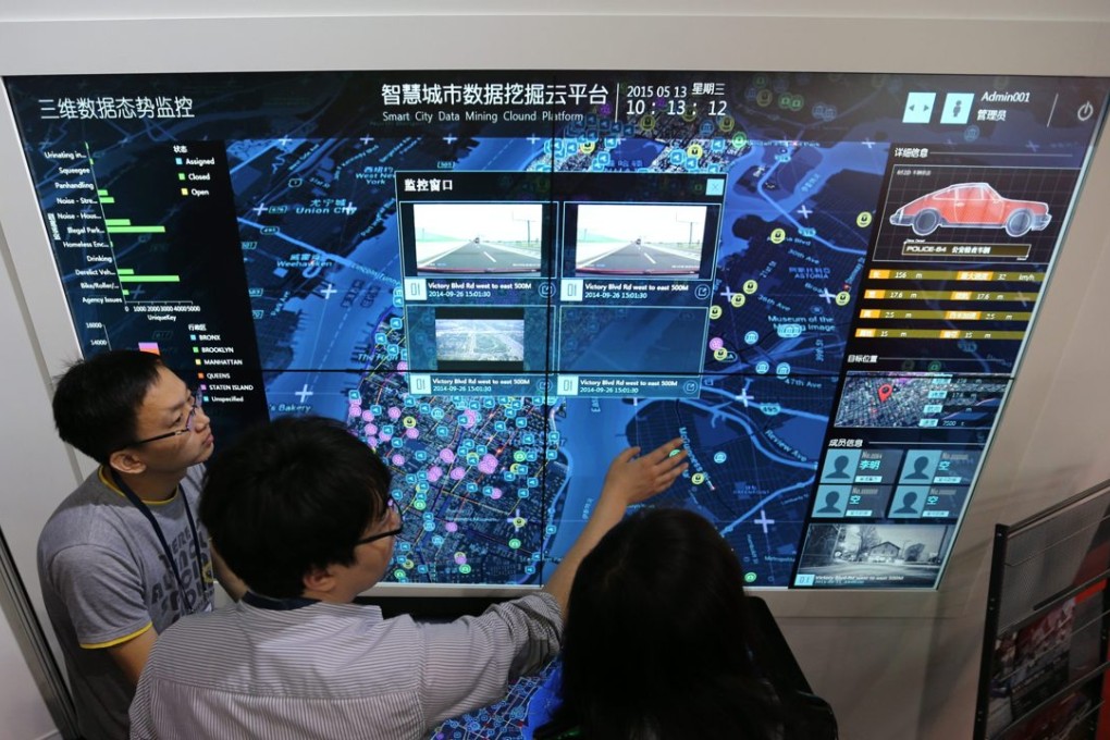 Visitors look at a screen displaying a smart city system at the 18th China Beijing International High-Tech Expo in Beijing on May 13, 2015. Photo: EPA