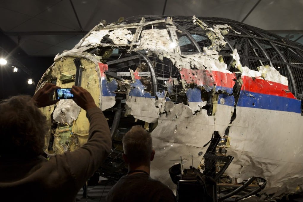 Journalists examine the reconstructed fuselage of MH17 after a 2015 presentation of the Dutch Safety Board's report into what caused the flight to break up high over Eastern Ukraine. Photo: AP