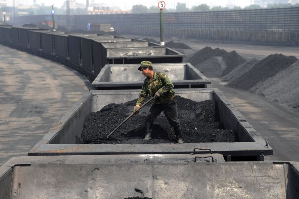 A worker levels the coal on a freight train in Taiyuan in northern China's Shanxi province. Photo: AP