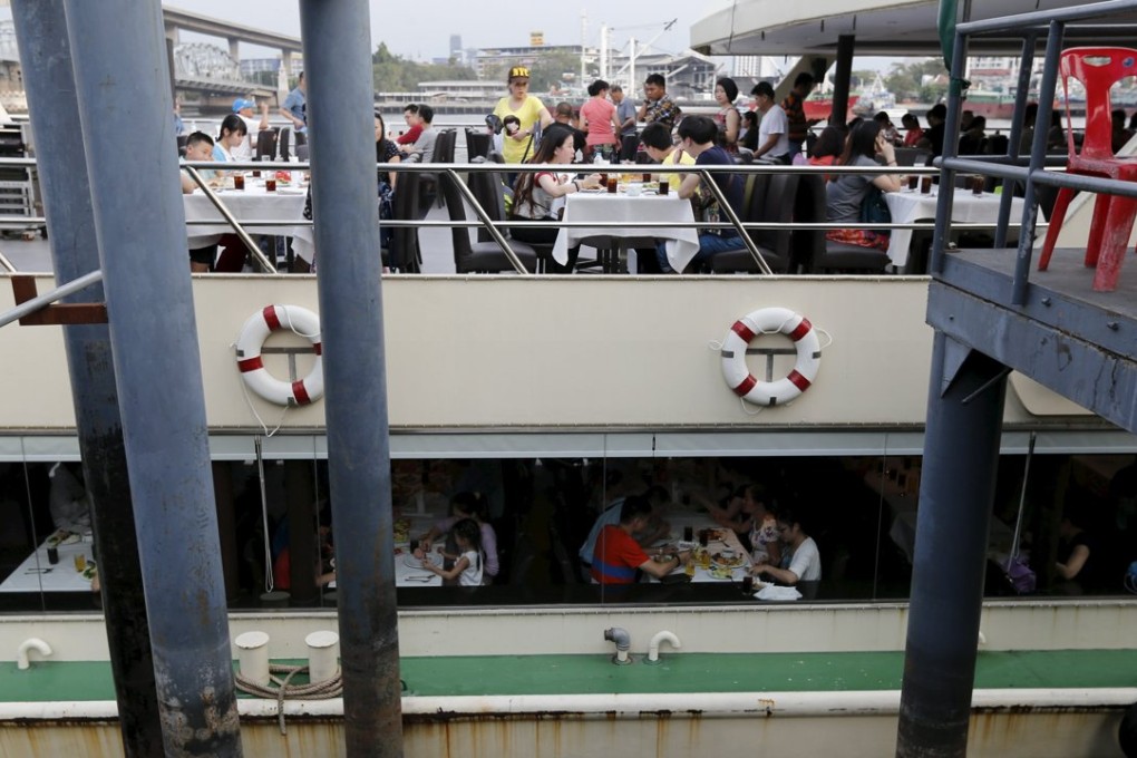 Chinese tourists dine onboard a boat at a pier at Chao Phraya River in Bangkok February 16, 2016. The perpetrators of last year's deadly explosion at a Bangkok shrine originally chose a pier packed with Chinese tourists as their primary target and had amassed enough chemicals to make 10 equally powerful bombs, the chief of Thailand's police bomb squad told Reuters. Picture taken February 16, 2016. REUTERS/Jorge Silva