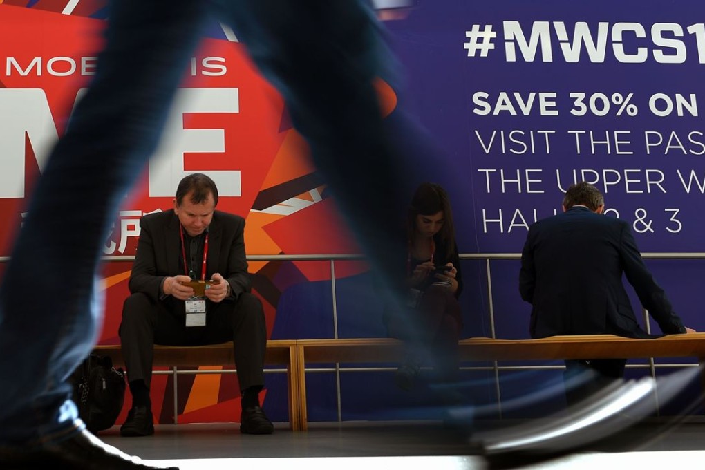 A visitor uses a smartphone at the Mobile World Congress in Barcelona last week. February 23 Photo: AFP