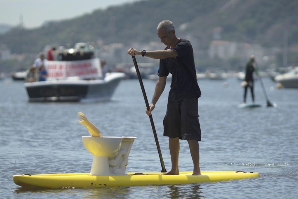 A man paddles his board into Guanabara bay, which activists say is full of rubbish. Photo: AP