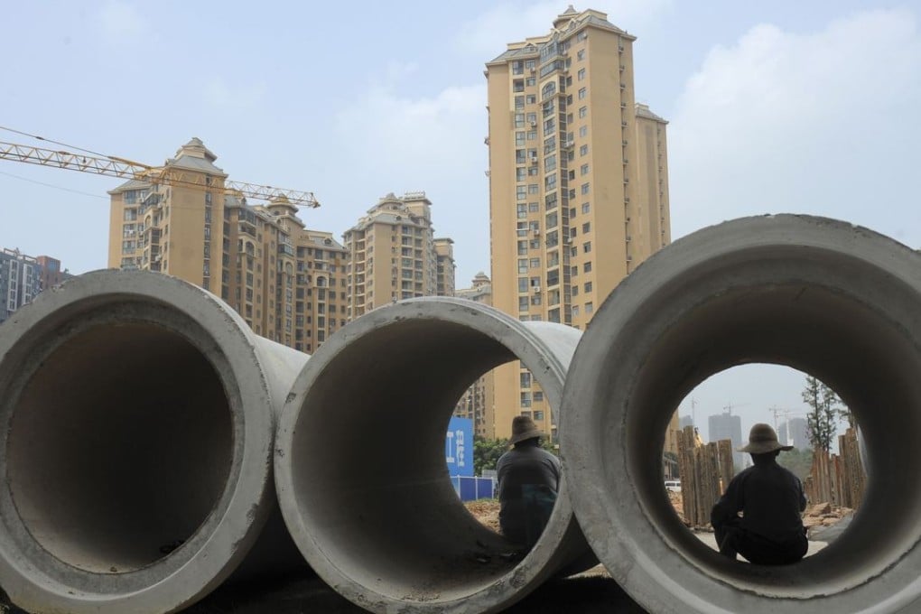 Labourers sit in cement pipes near residential buildings at a construction site in Wuhan, Hubei province. Photo: Reuters