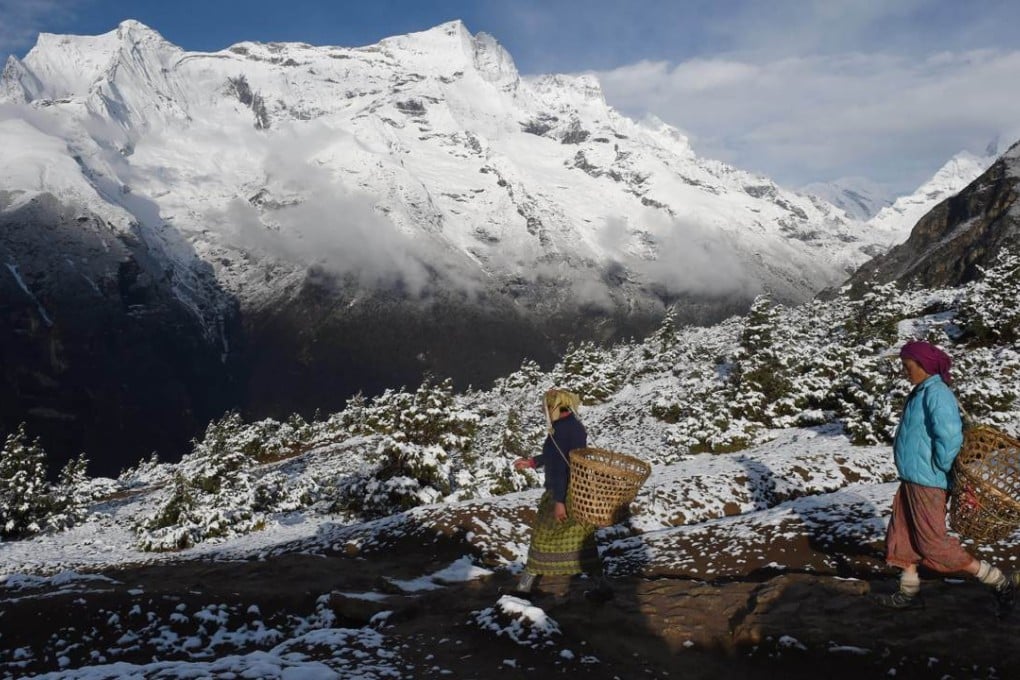 Nepalese villagers descend from higher elevations above the town of Namche, a popular stop for trekkers heading into the Everest region. Photo: AFP /Roberto Schmidt.