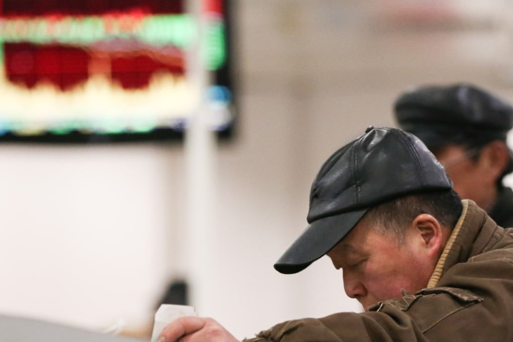 An investor looks through stock information at a trading terminal in a securities firm in Shanghai on February 25. Photo: Xinhua