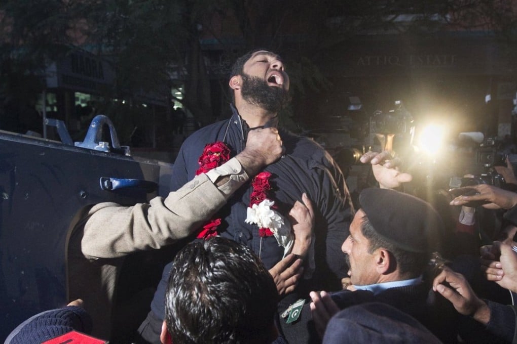 Mumtaz Qadri yells religious slogans as he is taken away by police following a court appearance in Islamabad, in January 2011. Photo: Reuters