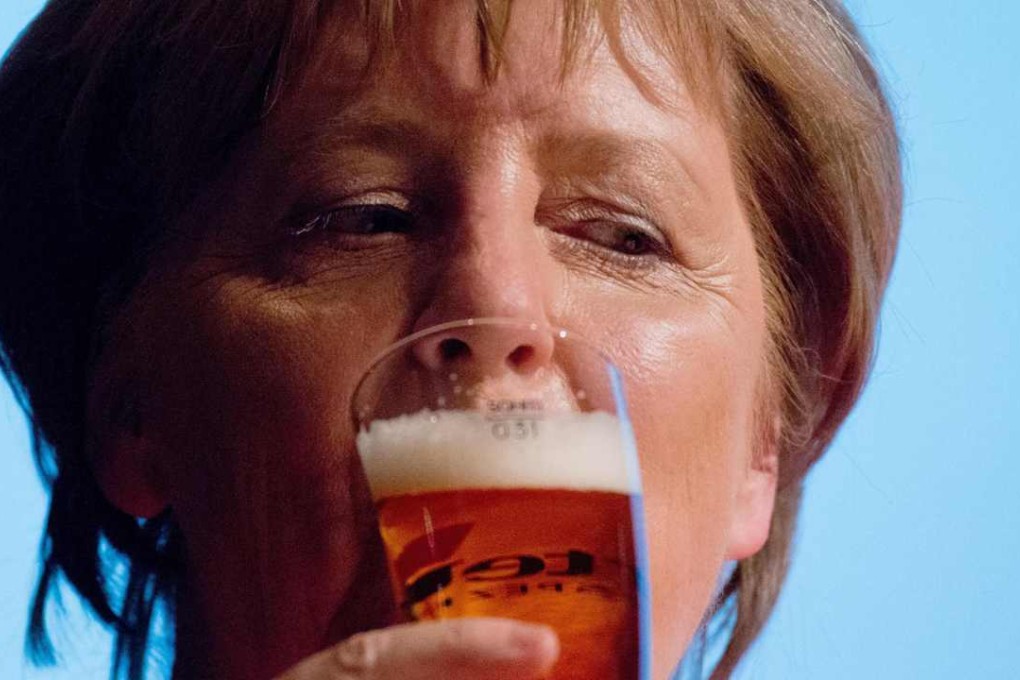 German Chancellor Angela Merkel drinks a beer at a meeting of her supporters at her constituency in Stralsund, nort-eastern Germay. Photo: AFP