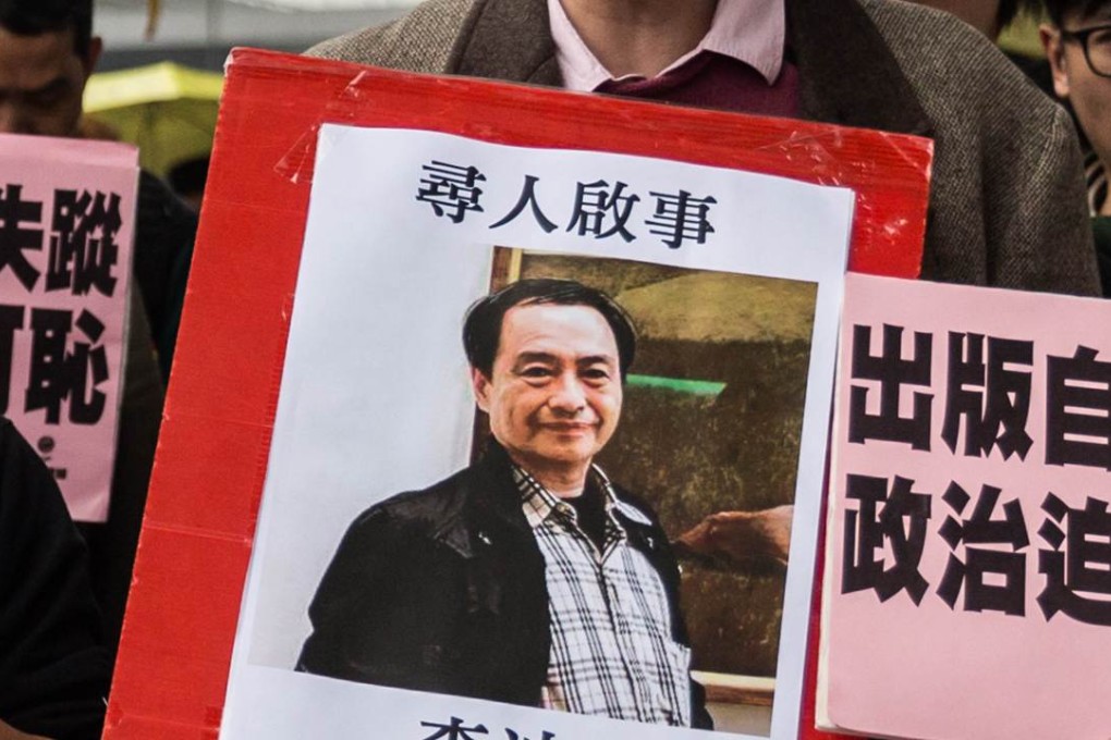 A man holds up a missing person notice for Lee Bo during a protest in Hong Kong. Photo: AFP