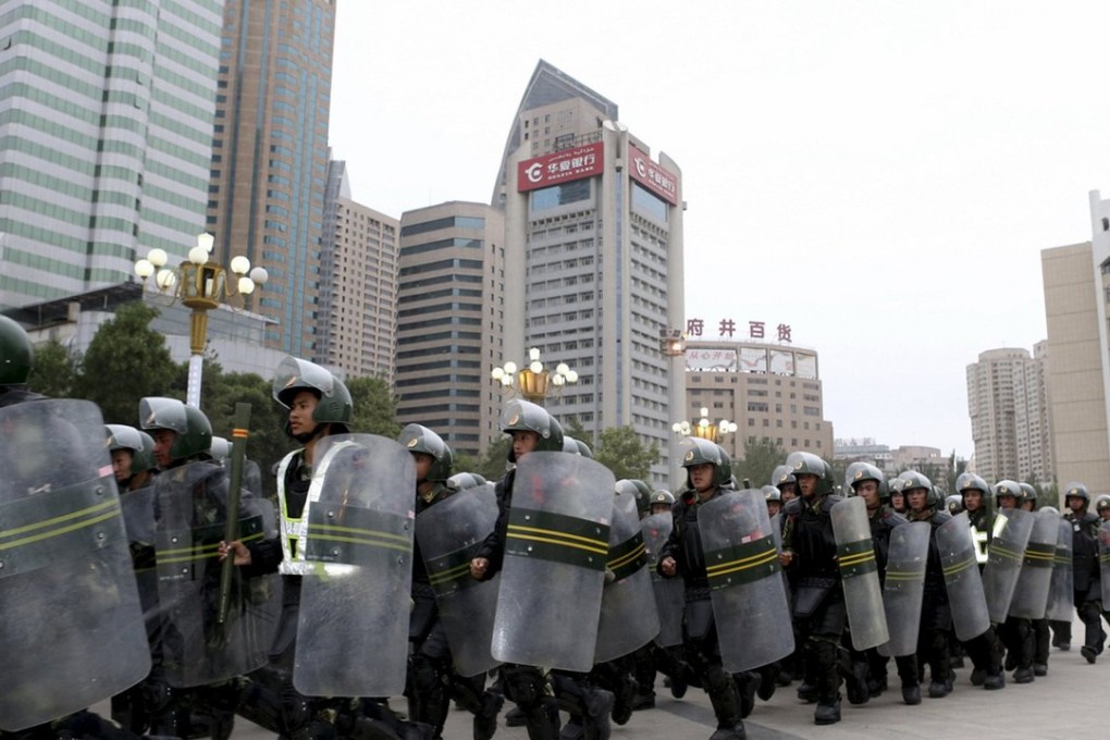 Armed paramilitary policemen run in formation during a gathering to mobilise anti-terror security operations in Urumqi, Xinjiang. Photo: Reuters