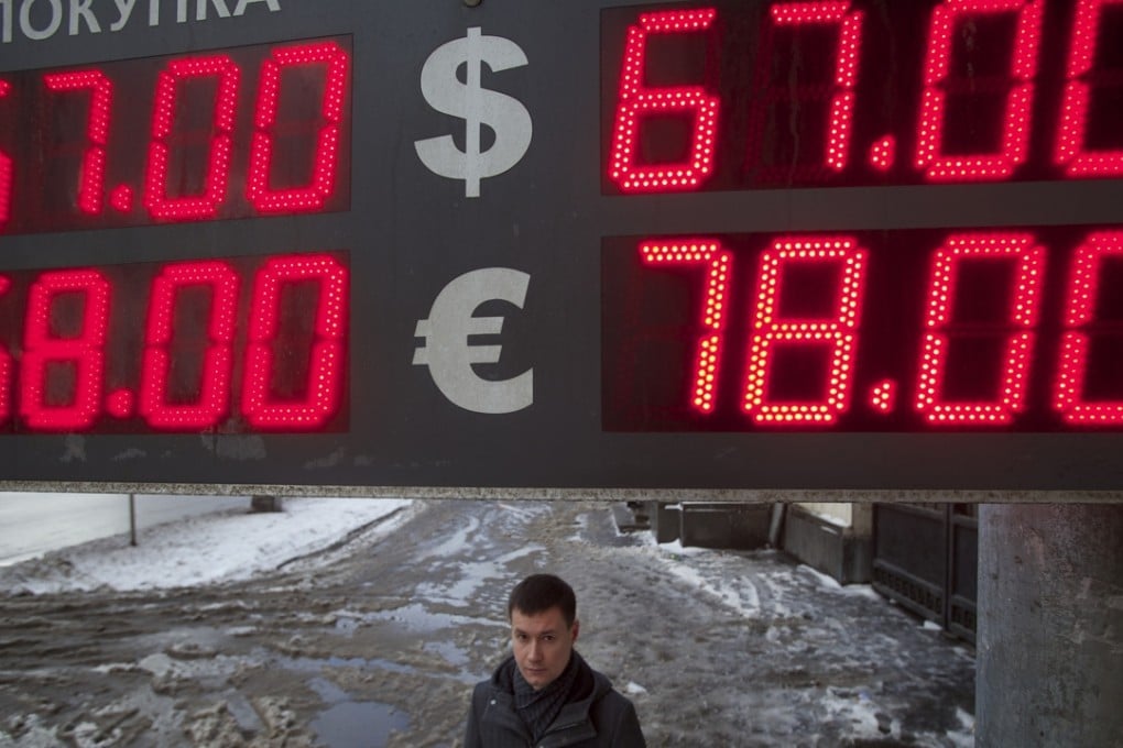 A man walks past an exchange office on a snowy Moscow street. The rouble has lost more than half of its value against the yuan since a currency swap deal was signed in October 2014. Photo: AP