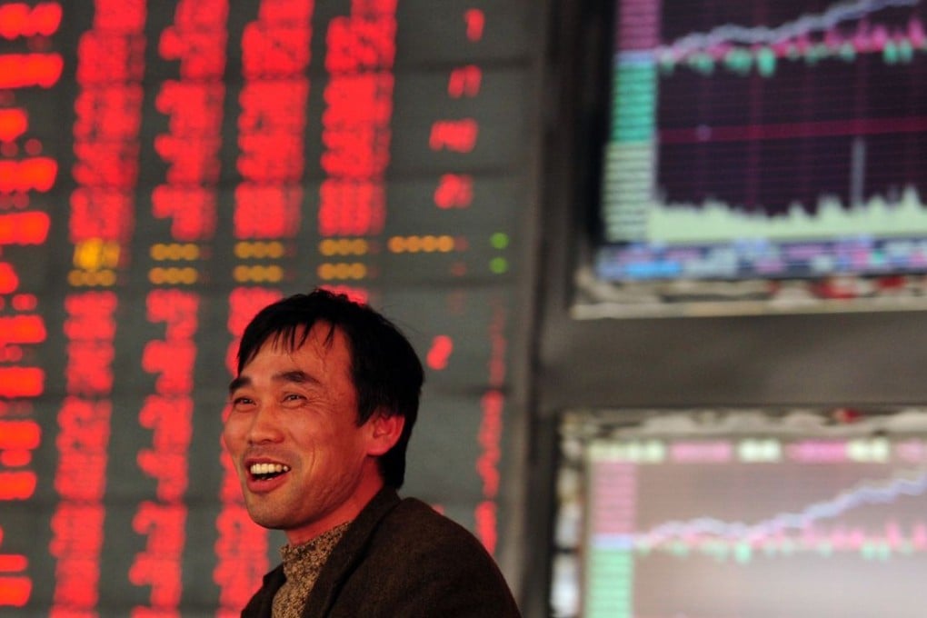 An investor makes his way in front of a screen showing stock market movements at a securities firm in Fuyang, Anhui province, on Wednesday. Photo: AFP