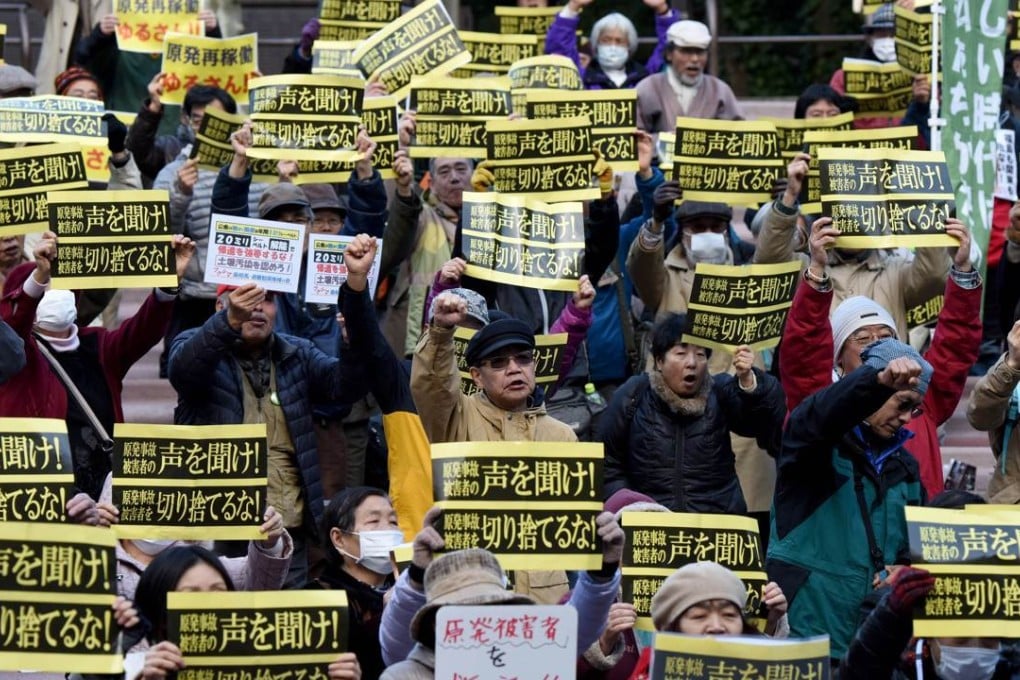 People hold banners as they shout slogans during a rally denouncing nuclear power plants in Tokyo. Photo: AFP