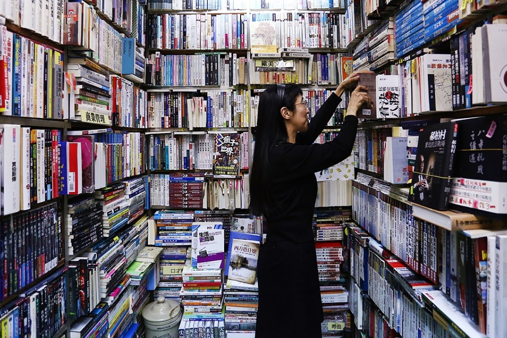Owner of Sam Kee Book Co, Caroline Chan, sorts out the books in her shop in Fortress Hill. Photo: Jonathan Wong