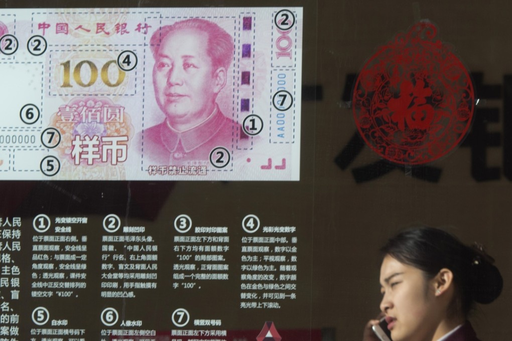 A Chinese woman speaks on her phone near a display highlighting the new Chinese bank notes at a bank in Beijing, Photo: AP