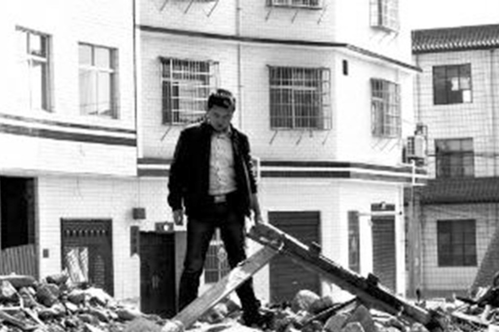 Wang, a migrant worker, stands in the ruins of his home that was demolished in his absence without his knowledge. Photo: Chinese Business View