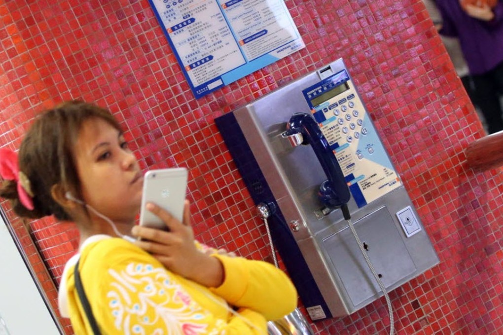 A traveller with a smartphone has no need for the public payphone at an MTR station. Photo: Felix Wong.