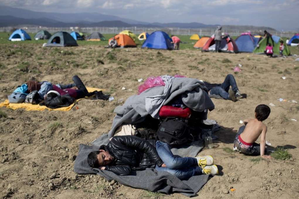 Refugees sleep on the field as they wait to be allowed to cross the border to Macedonia in the northern Greek border station of Idomeni on Thursday. Photo: AP